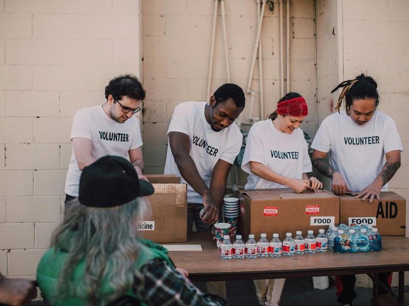 4 volunteers working together packing essentials.
