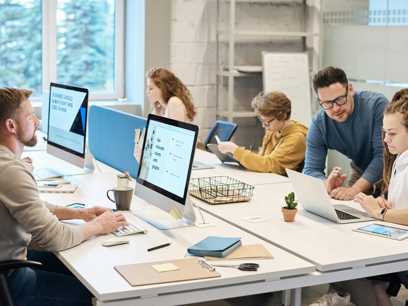 People sat at desks working together and independently