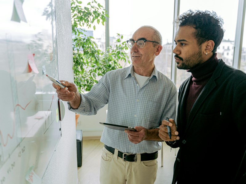 Two people analysing content on a whiteboard