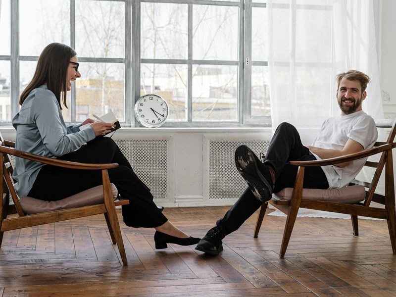 Two people sat across from each other expressing joy