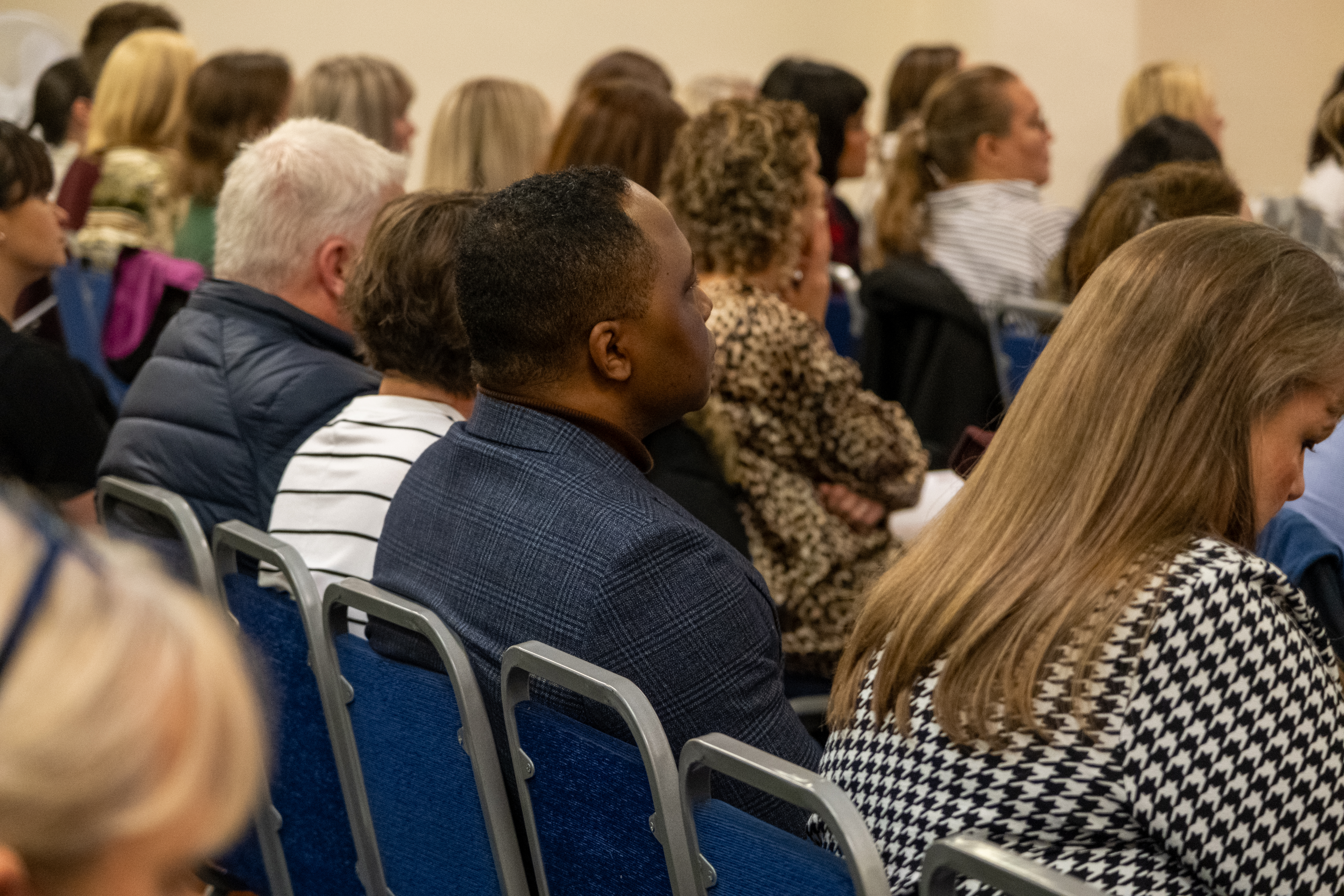 Audience sat listening to a speaker, engaged.