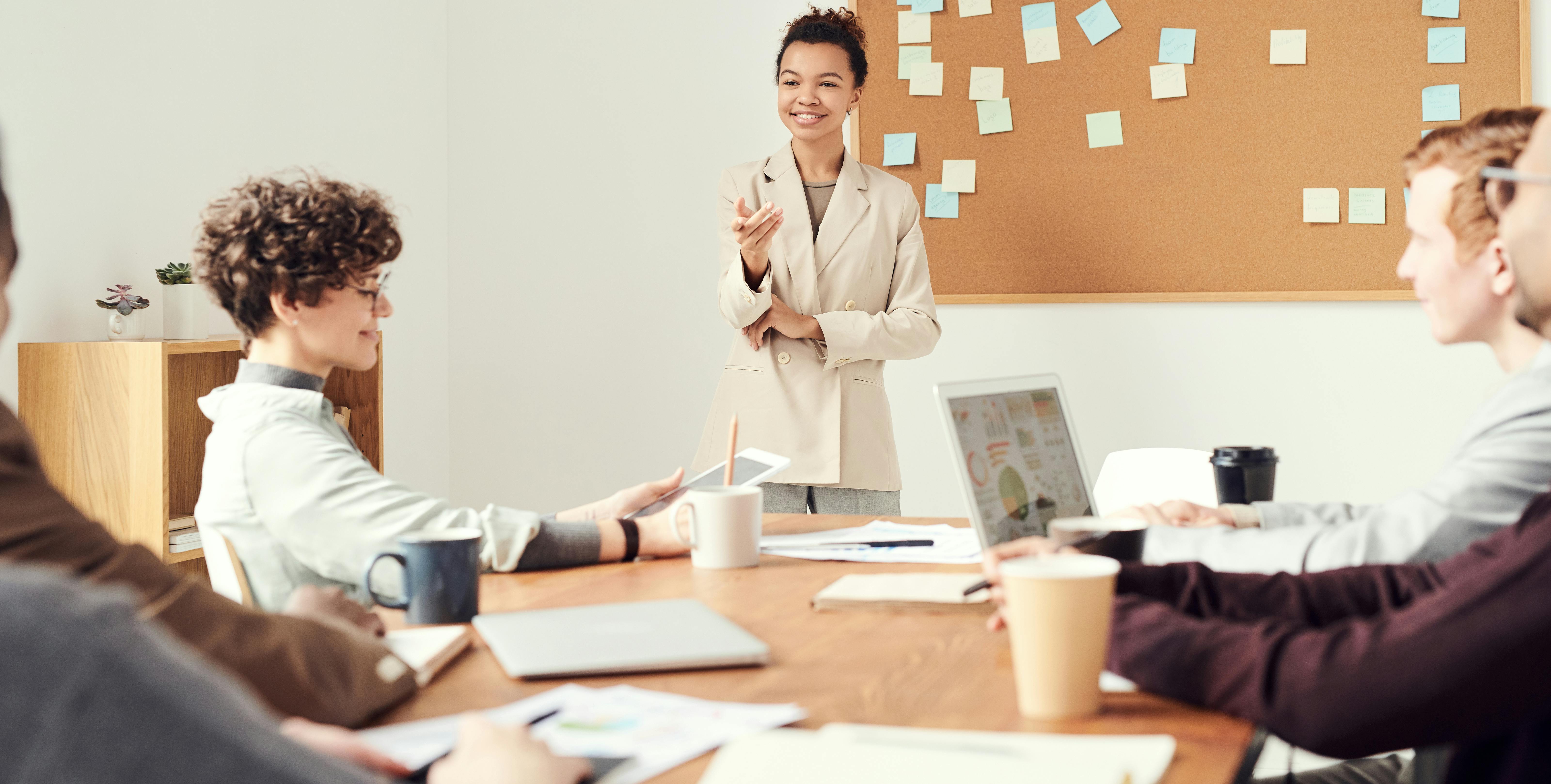 People working in an office room happily with good wellbeing and management practice
